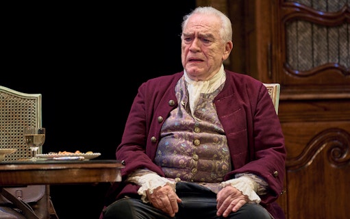 Elderly man in period costume sitting at a table with a drink and food, related to "The Score.