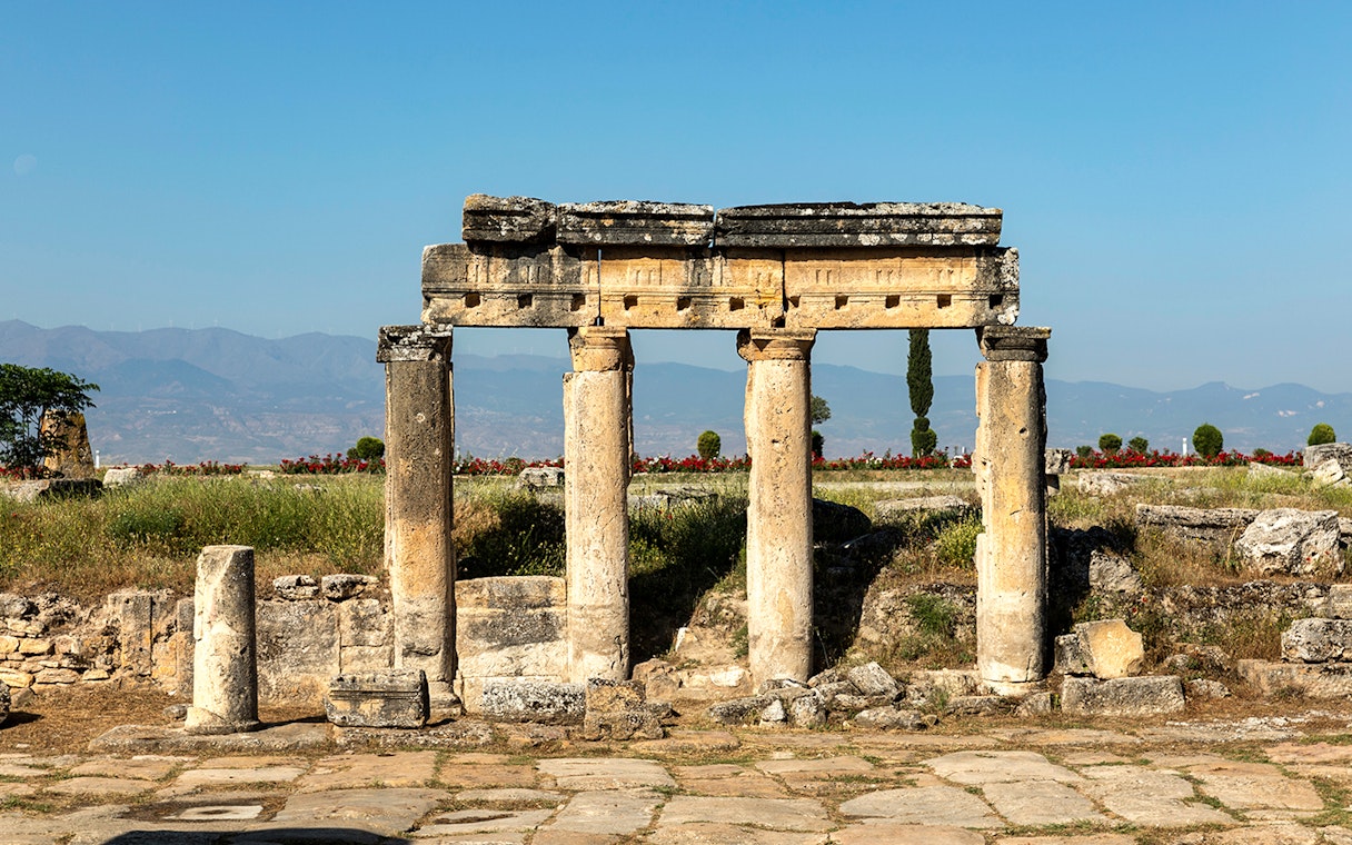 Ruins of the Temple of Apollo in Hierapolis with mountains in the background.