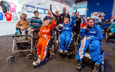 Elderly group in wheelchairs celebrating at iFly Sydney Indoor Skydiving.