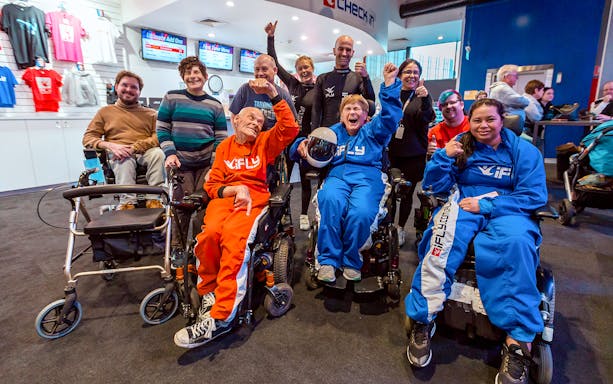 Elderly group in wheelchairs celebrating at iFly Sydney Indoor Skydiving.