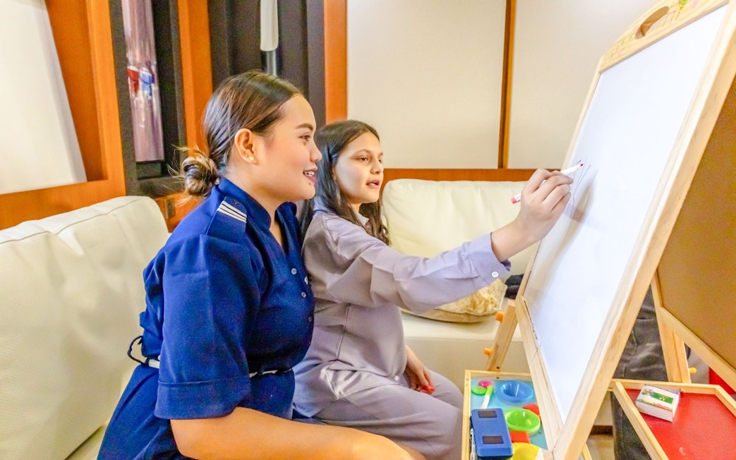 Cruise guide interacting with tourists using a whiteboard.