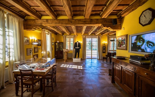 Luciano Pavarotti House Museum interior with memorabilia and a tuxedo display.