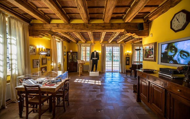 Luciano Pavarotti House Museum interior with memorabilia and a tuxedo display.