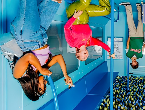 Visitors enjoying an upside-down room at The Upside Down Amsterdam exhibit.