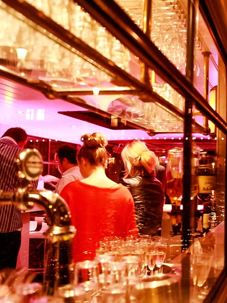 Amsterdam canal cruise with illuminated bridges and passengers enjoying the view.
