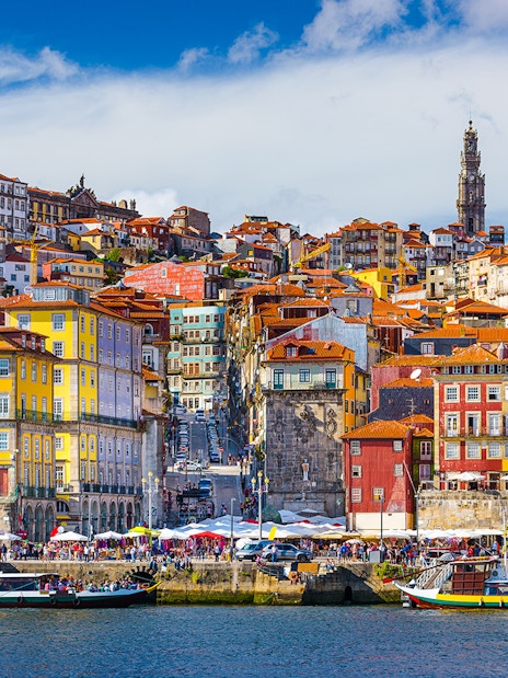 Colorful buildings along the Douro River in Porto, Portugal, with boats and historic architecture.