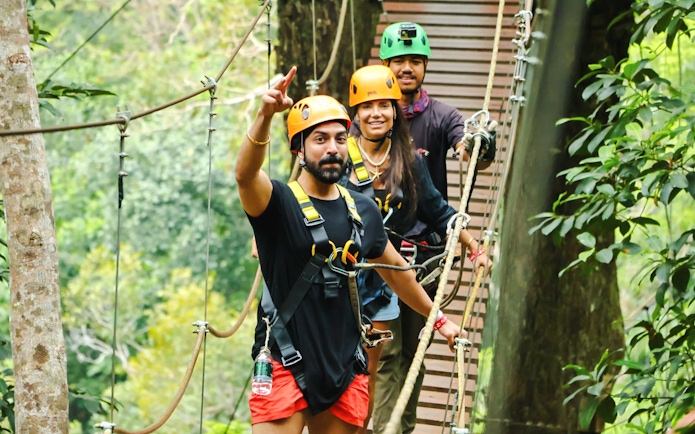 Participants on a zipline platform at Flying Hanuman, Phuket, wearing safety gear.