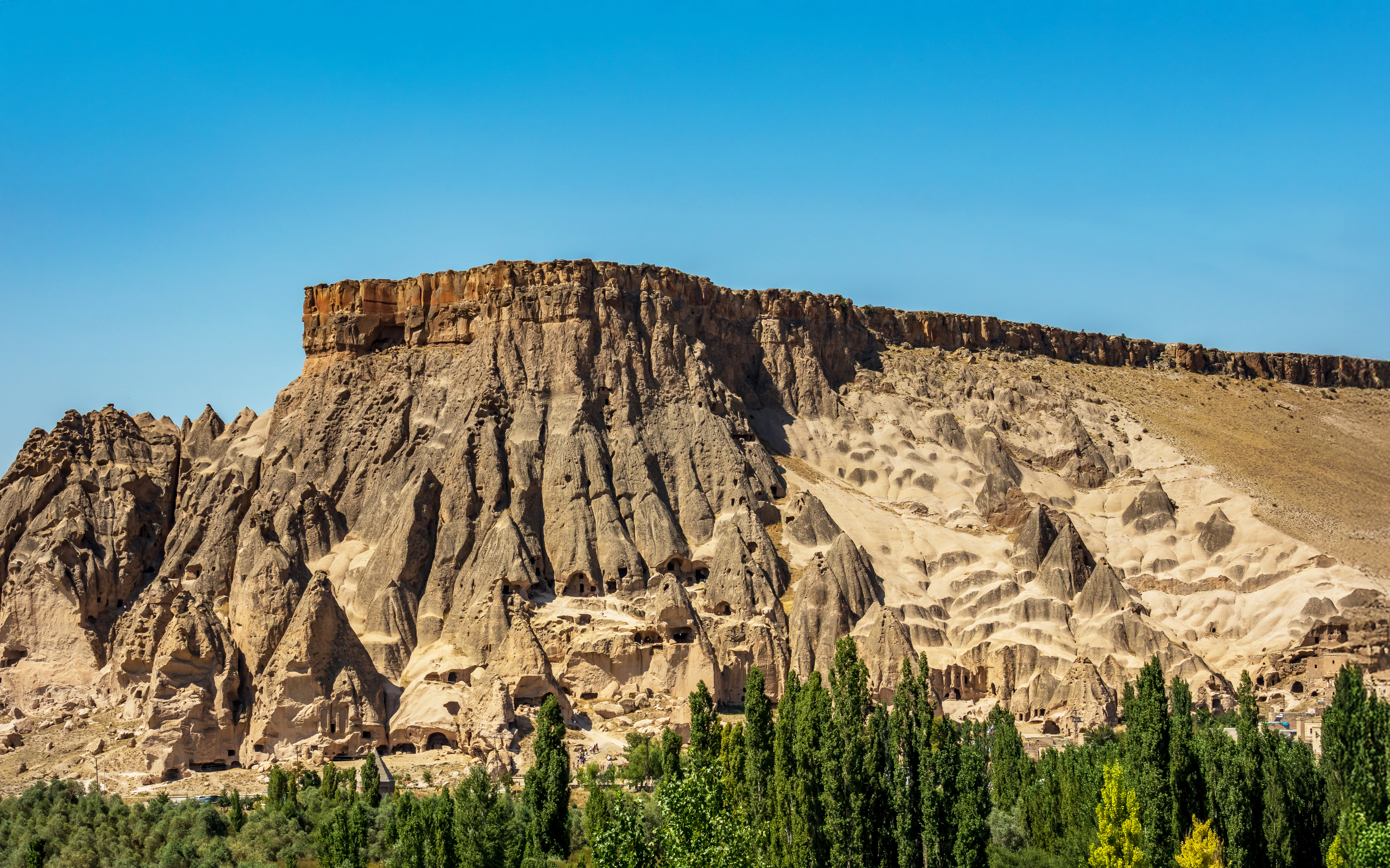 Panoramic view of Ihlara Valley's rock formations and greenery, Cappadocia, Turkey.
