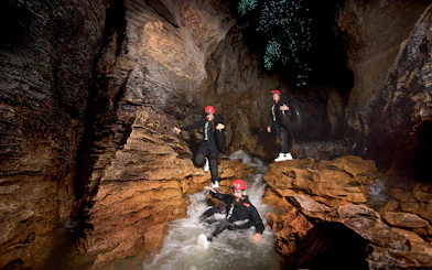 Adventurers black water rafting in Waitomo cave with glowworms above.