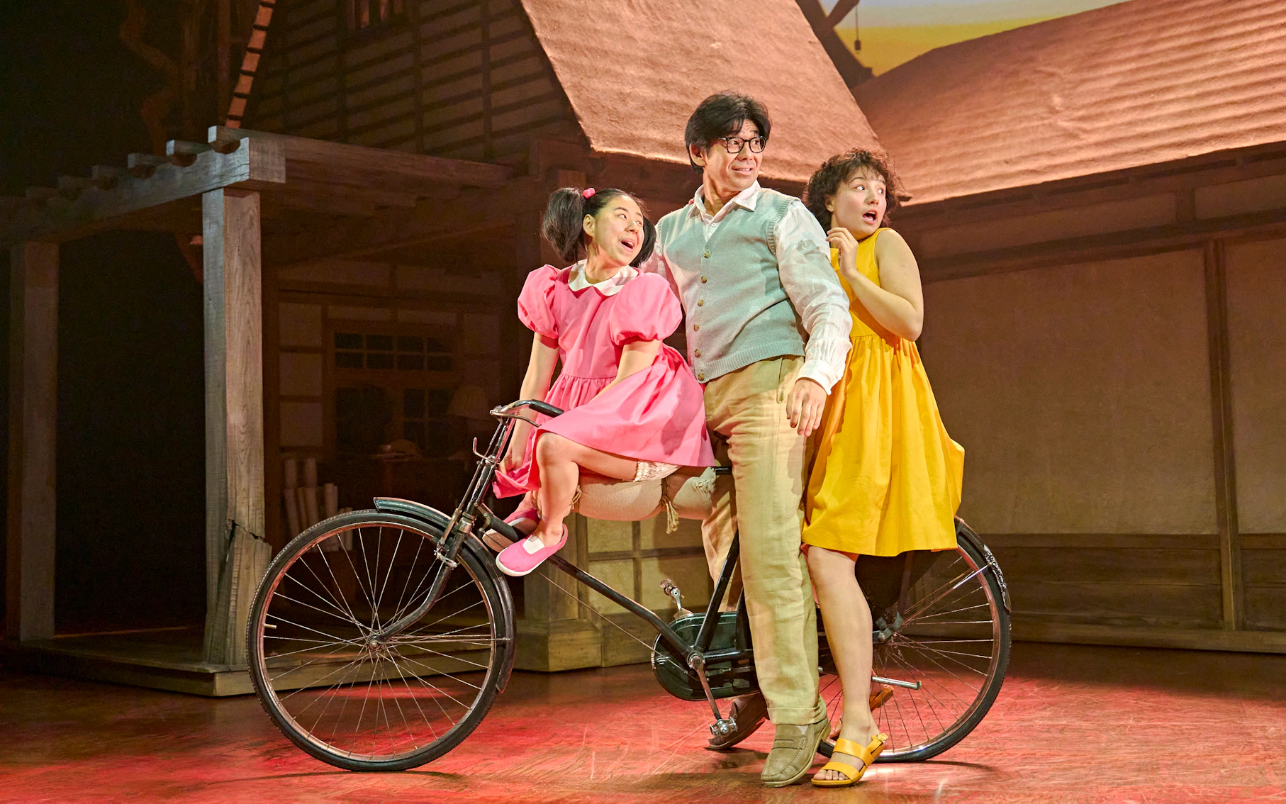 Stage actors on a bicycle in a scene from My Neighbour Totoro production.