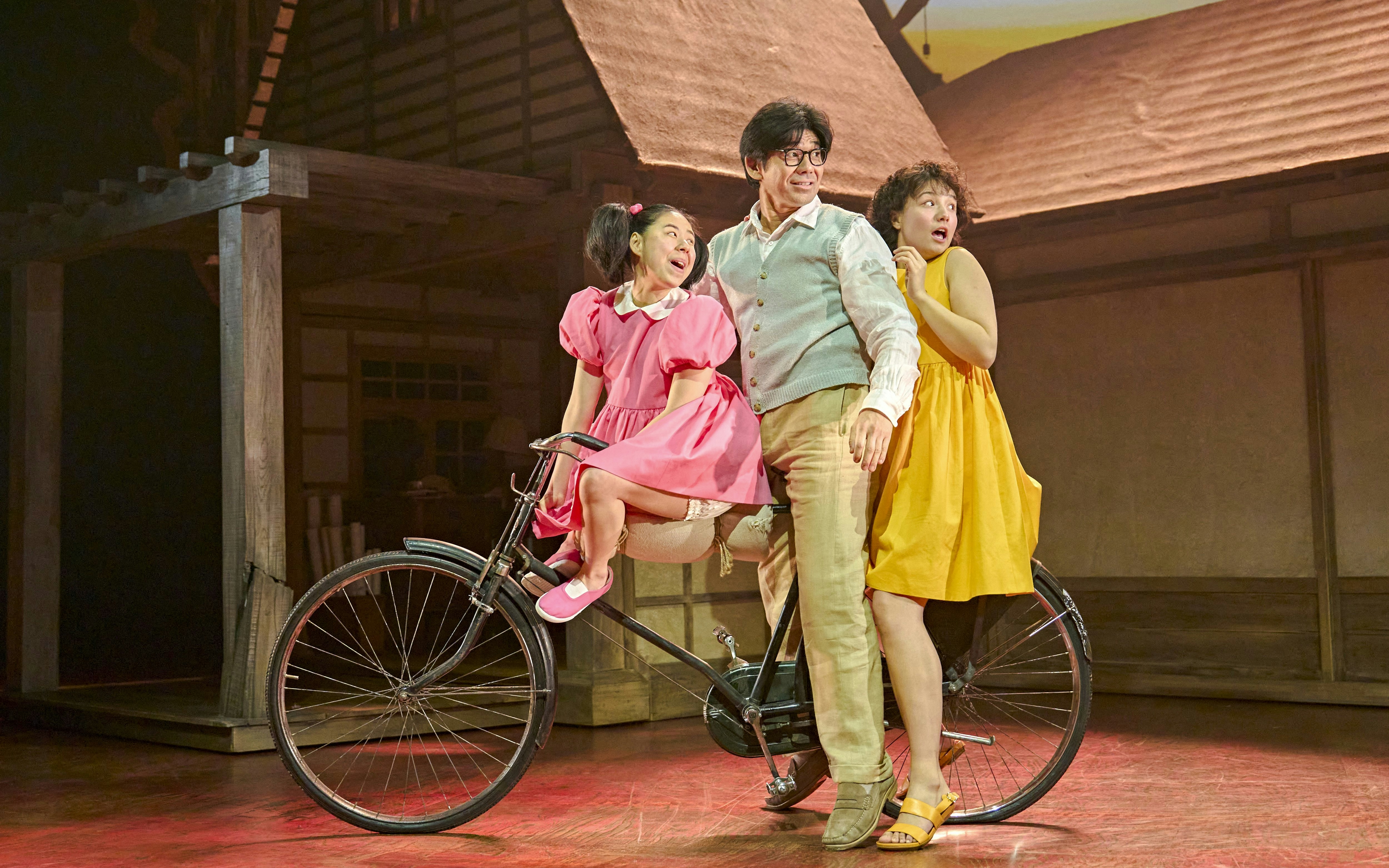 Stage actors on a bicycle in a scene from My Neighbour Totoro production.