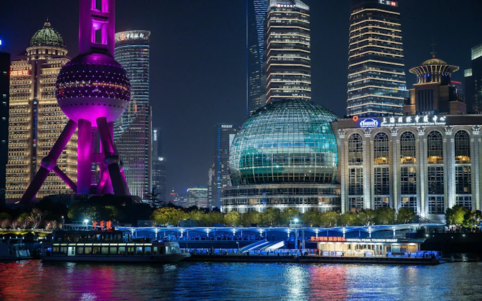Cruise on Huangpu River past Shanghai's Oriental Pearl Tower and skyline at night.