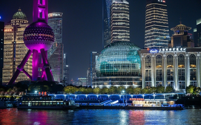 Cruise on Huangpu River past Shanghai's Oriental Pearl Tower and skyline at night.
