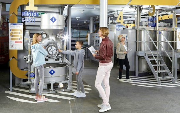 Visitors exploring machinery at Chocolate Museum Cologne.