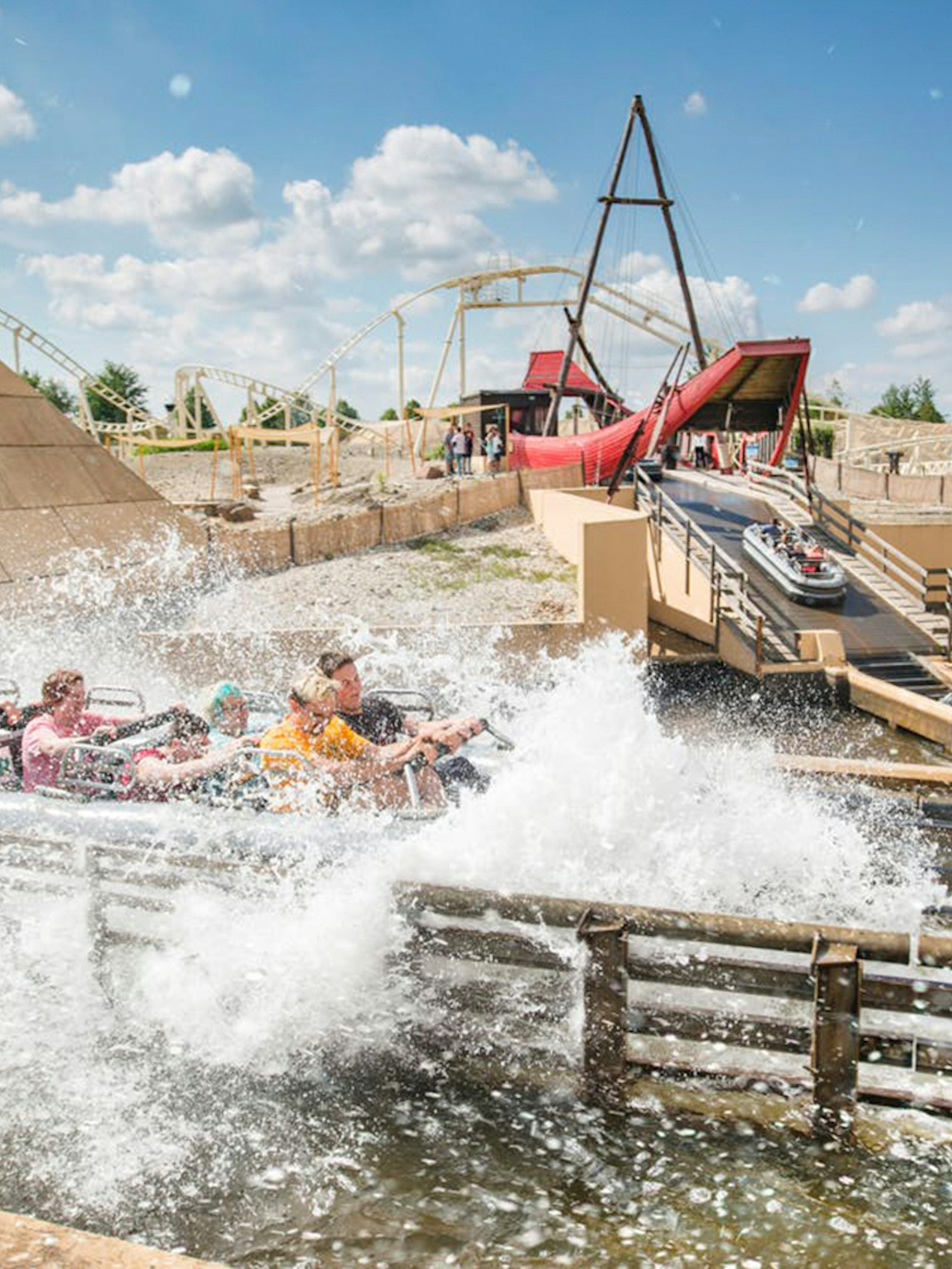 Guests on a water ride at BELANTIS Adventure Park with splashing waves.