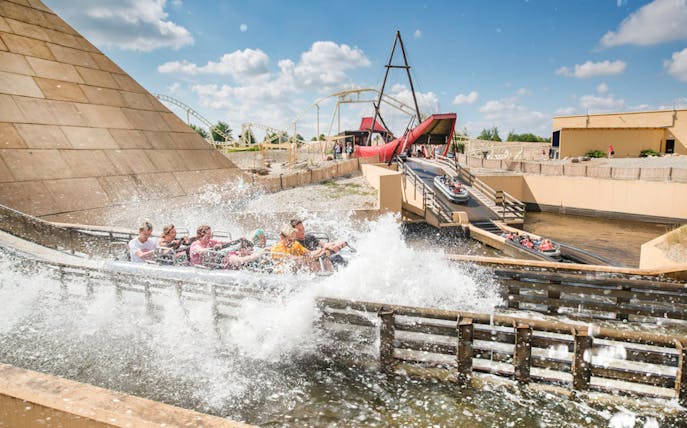 Guests on a water ride at BELANTIS Adventure Park with splashing waves.