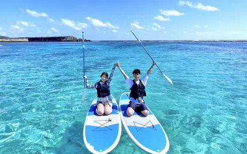 Paddleboarders on clear blue water during Miyako Beach SUP tour, Okinawa.