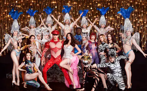 Cabaret performers in vibrant costumes on stage, Paris New Year's Eve show.