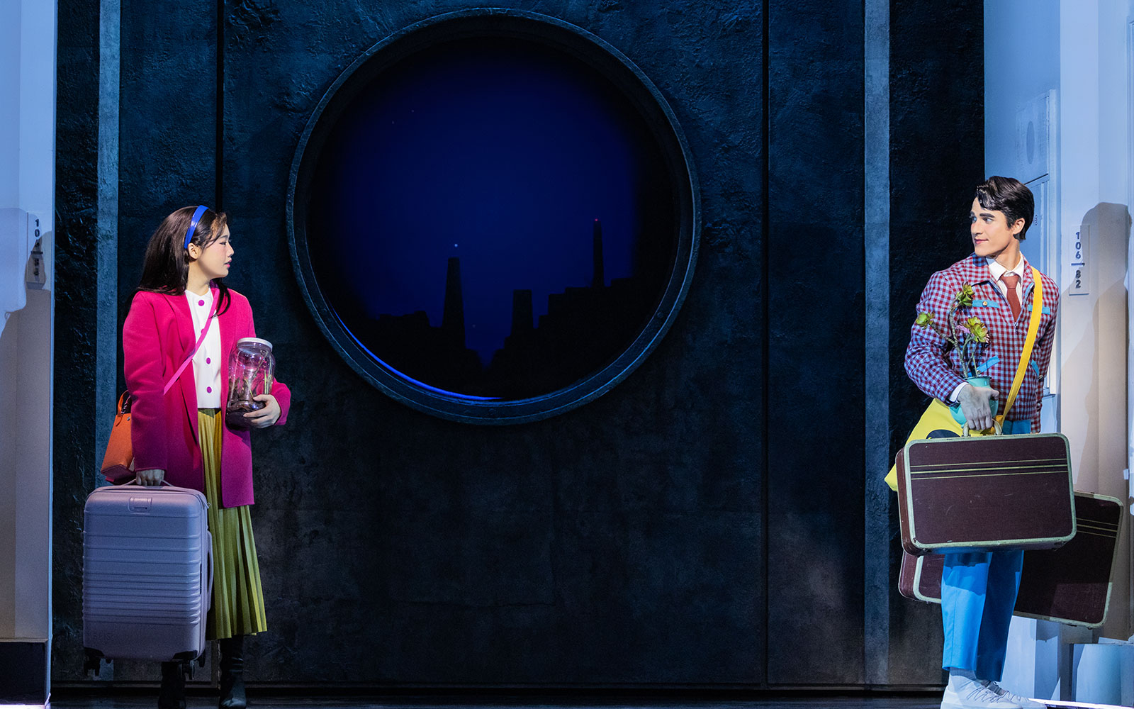 Actors on stage during Maybe Happy Ending Broadway show, holding luggage and props.