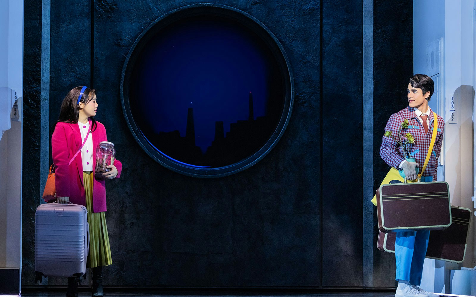 Actors on stage during Maybe Happy Ending Broadway show, holding luggage and props.