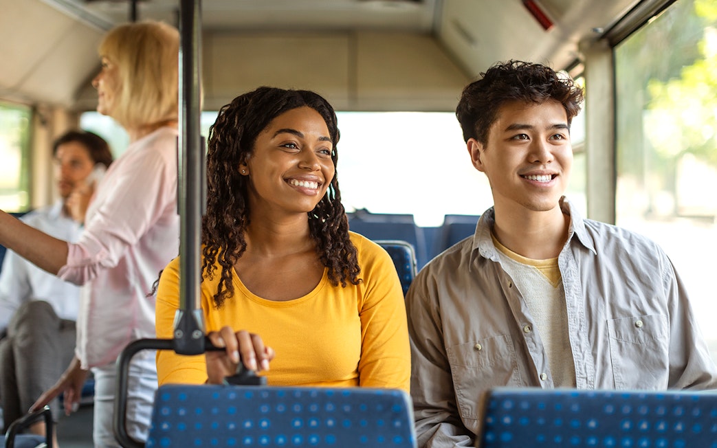 Guests smiling during a bus transfer experience.
