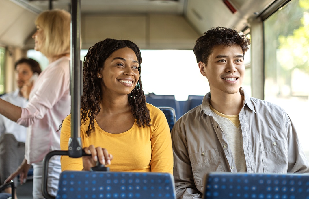 Guests smiling during a bus transfer experience.