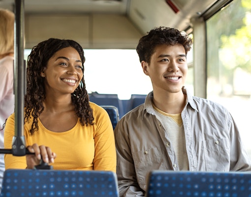 Guests smiling during a bus transfer experience.