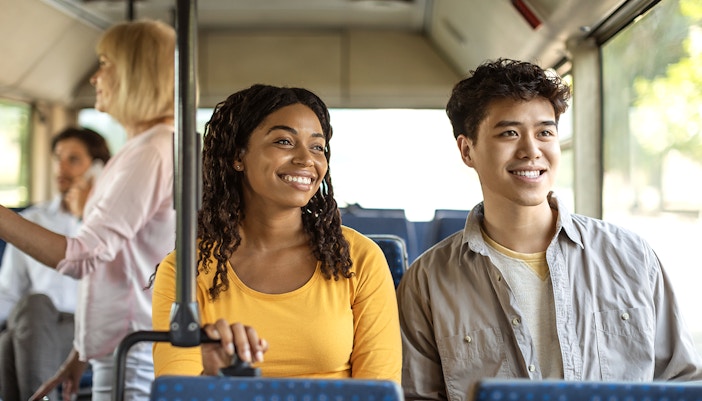 Guests smiling during a bus transfer experience.