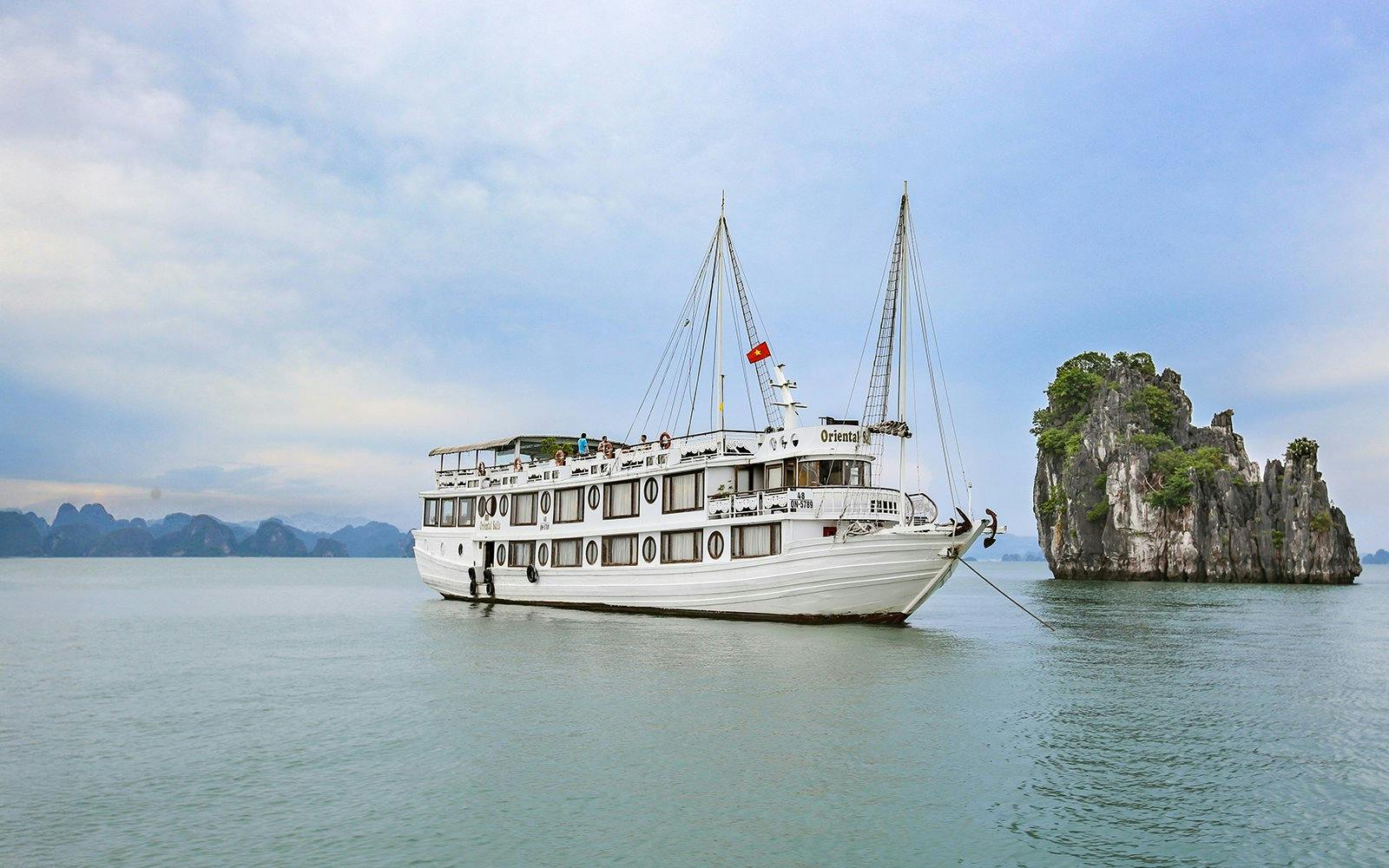 Cruise ship on Halong Bay with limestone karst in background.