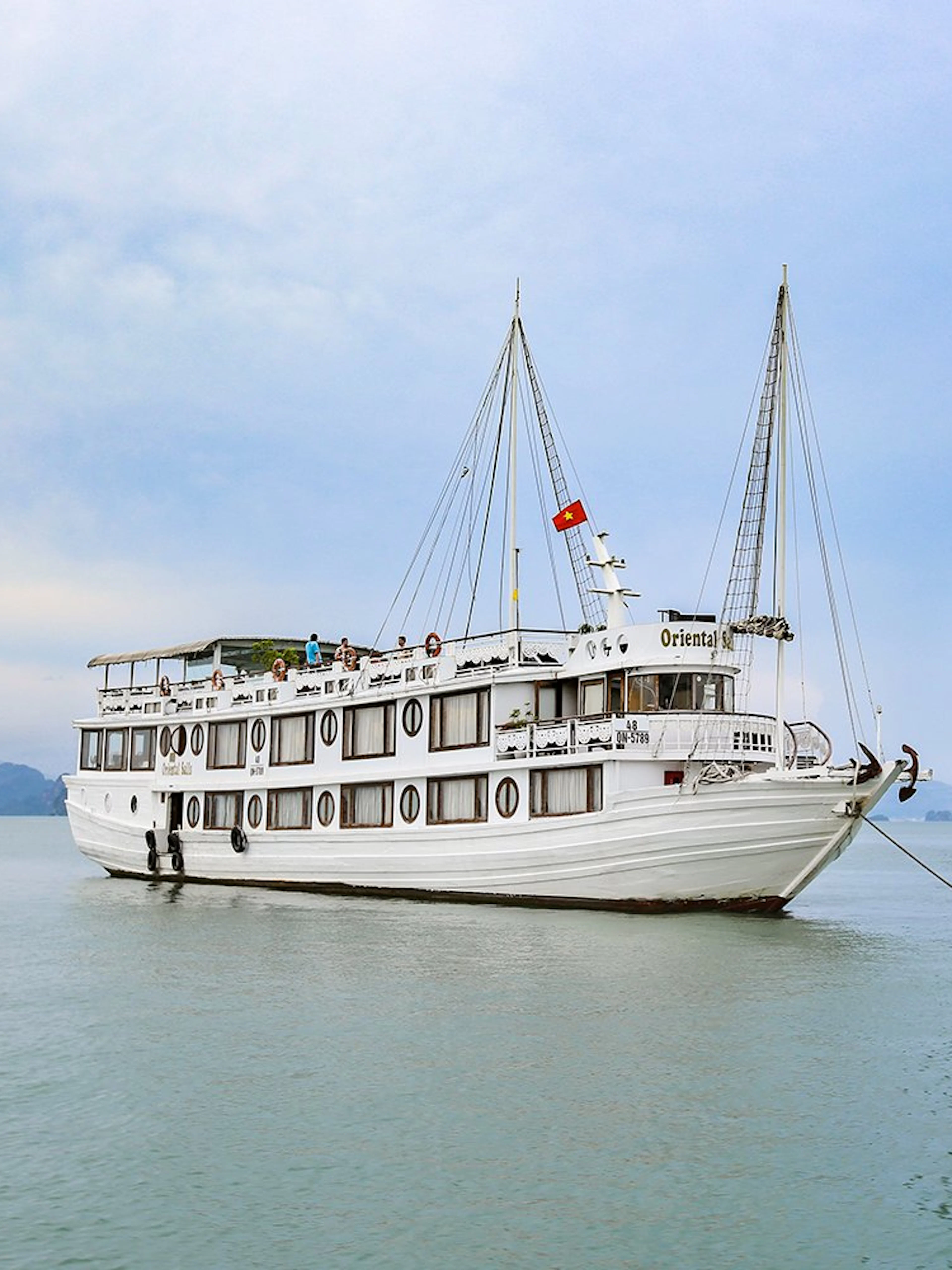 Cruise ship on Halong Bay with limestone karst in background.