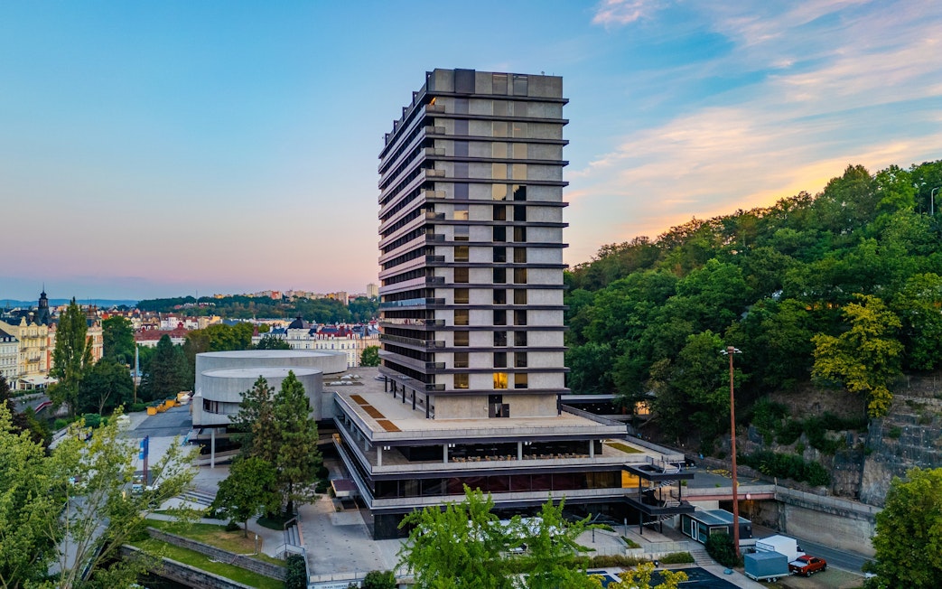 Hotel Thermal building in Karlovy Vary with surrounding greenery and cityscape.