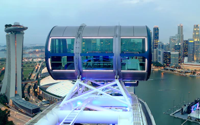 Singapore Flyer cabin illuminated for New Year's Eve, overlooking Marina Bay skyline.