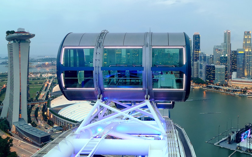 Singapore Flyer cabin illuminated for New Year's Eve, overlooking Marina Bay skyline.