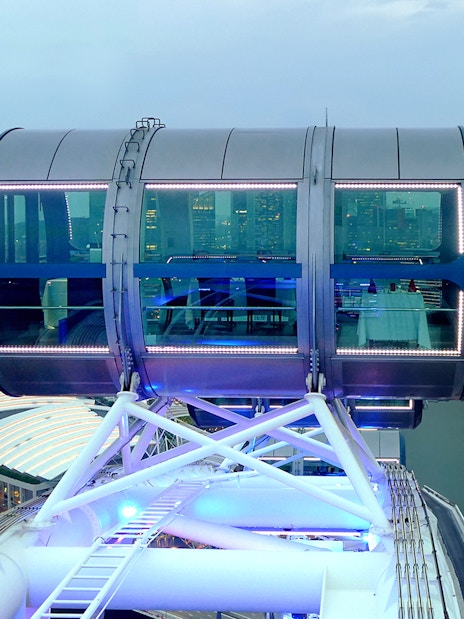 Singapore Flyer cabin illuminated for New Year's Eve, overlooking Marina Bay skyline.