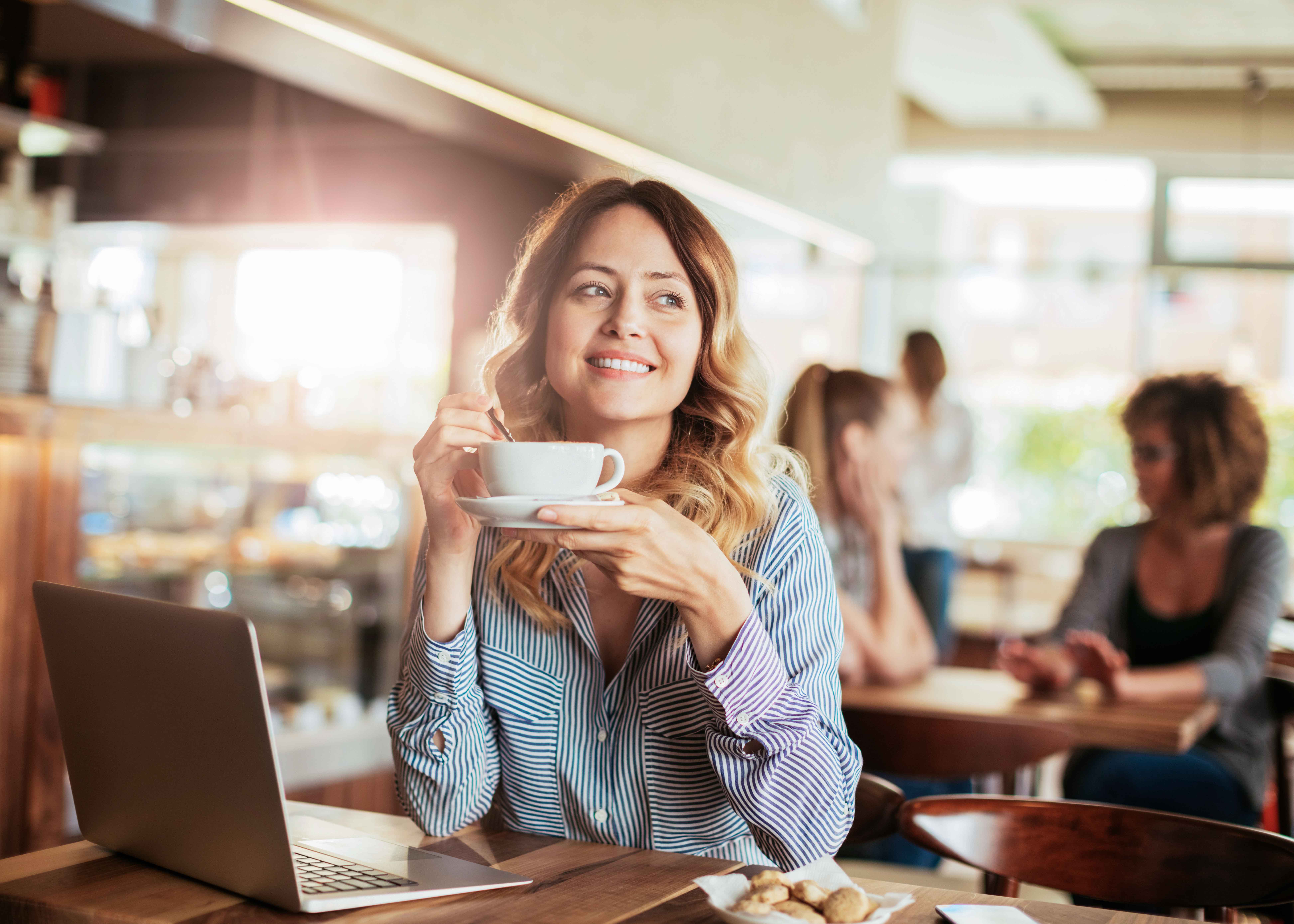 Café cerca del Museo del Louvre de París, con asientos al aire libre y vistas a la emblemática entrada de la pirámide.