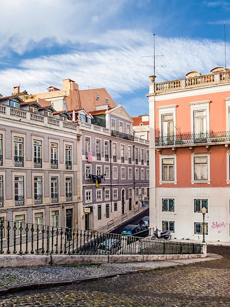 Lisbon street with colorful buildings and cobblestone path on electric bike tour.