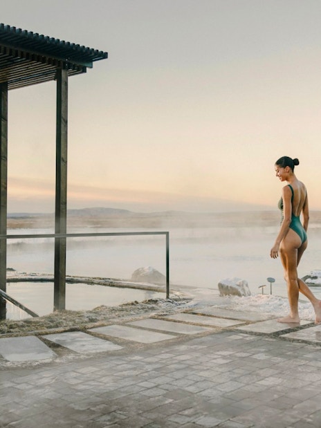 Guest walking by the cold pool in Laugarás Lagoon, Iceland at sunrise.