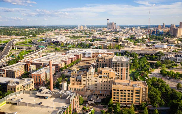 Aerial view of San Antonio skyline with historic buildings and highways.