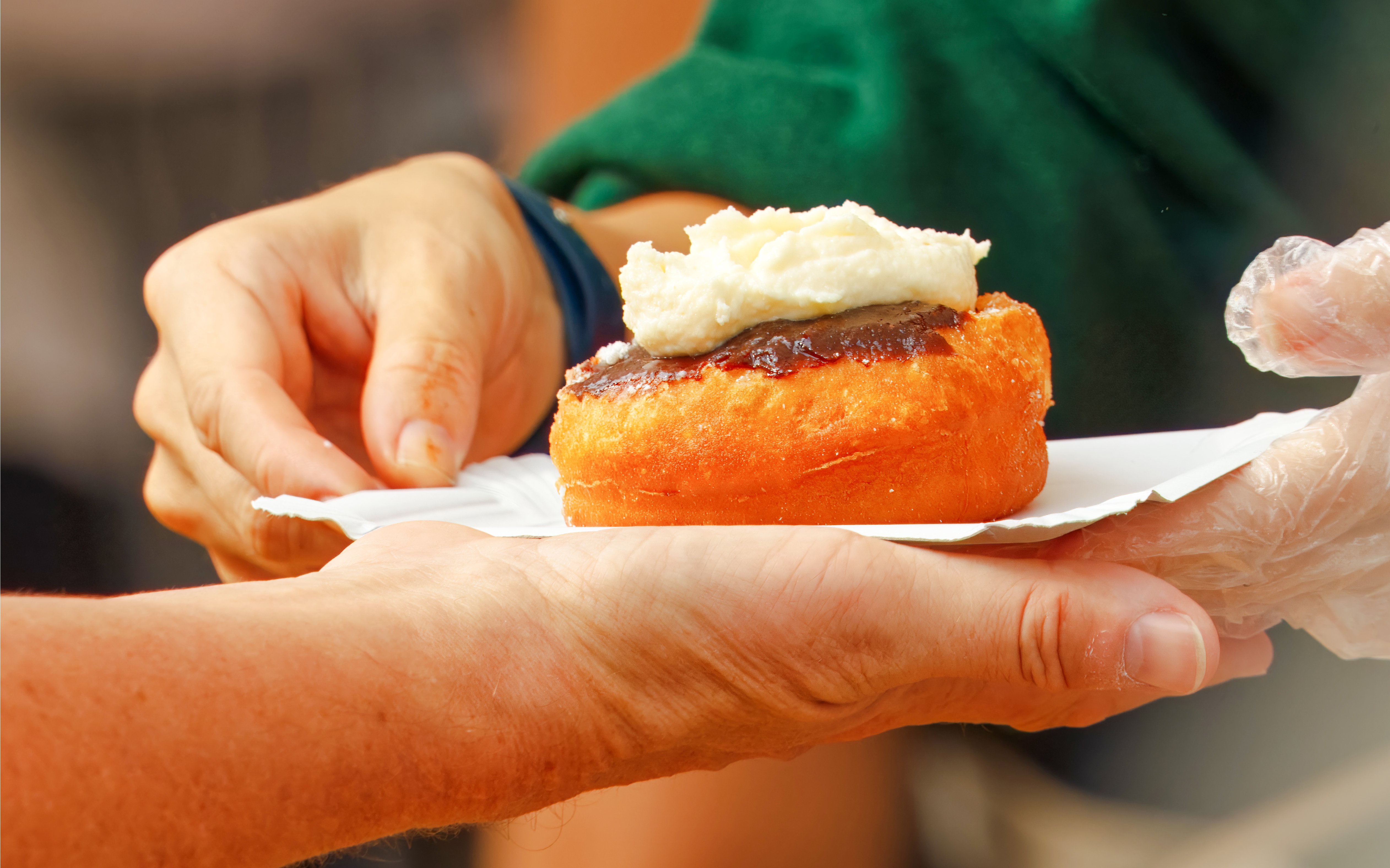 Handing over a pastry with cream at Schwangauer Käserei.