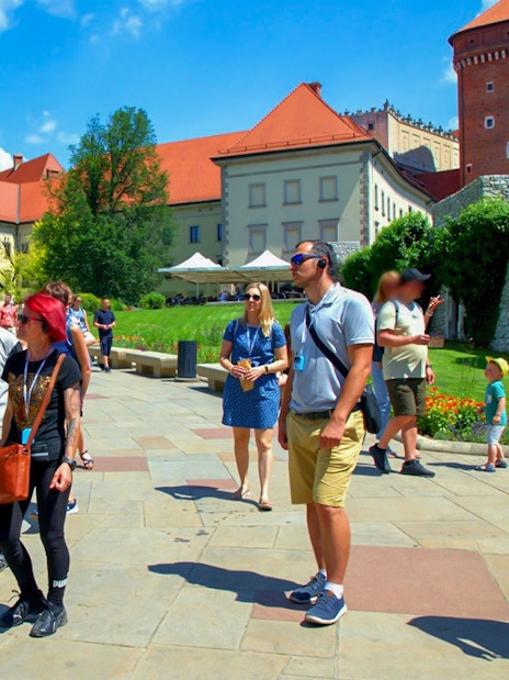 Visitors exploring Wawel Castle grounds on a guided tour in Krakow, Poland.