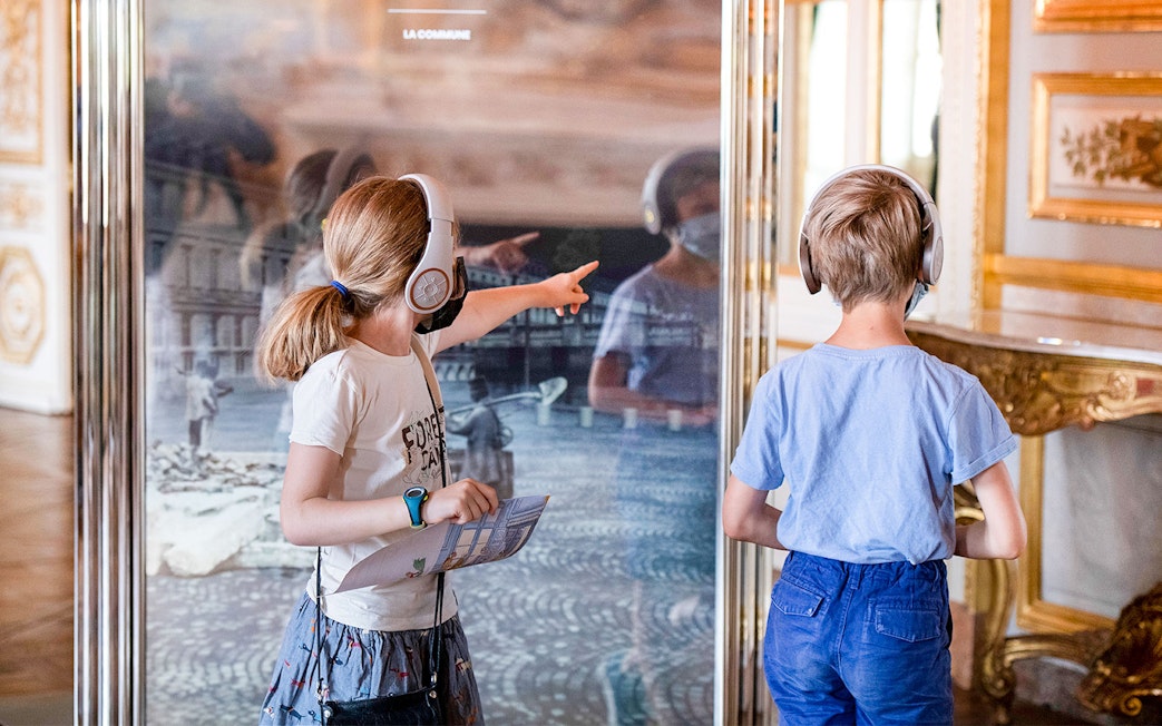 Children with headphones exploring Hôtel de la Marine exhibit.