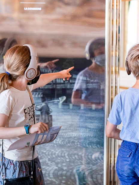 Children with headphones exploring Hôtel de la Marine exhibit.