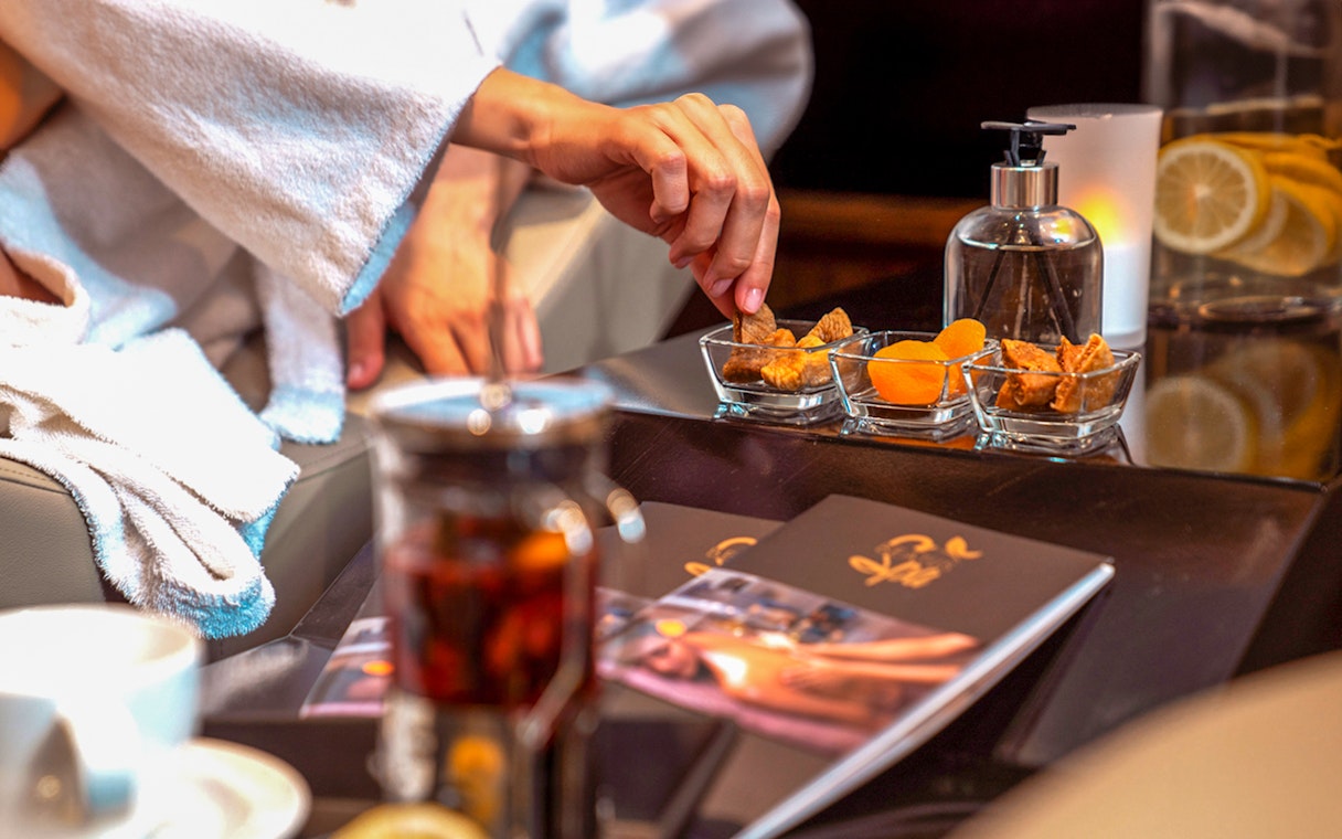 Hand reaching for dried fruits at Istanbul Private Turkish Bath spa.