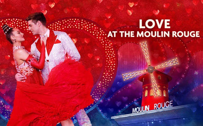 Dancers in red attire at Moulin Rouge with windmill backdrop, Valentine's Day theme.