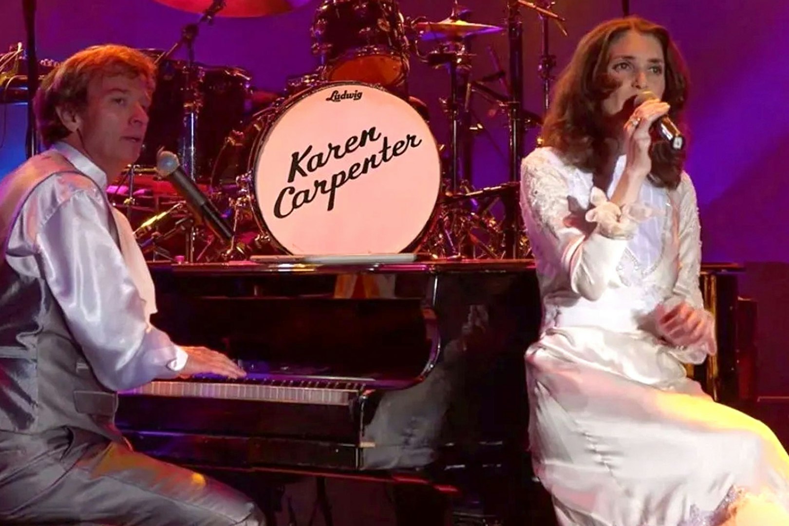 Performers on stage during Carpenters Legacy show, with a piano and drum set.