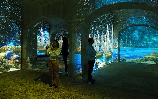 Porto Legends immersive experience with projected ships and stars.
