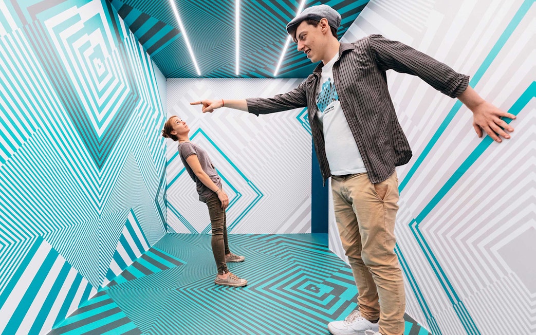 Visitors interacting in an optical illusion room at the Museum of Illusions.