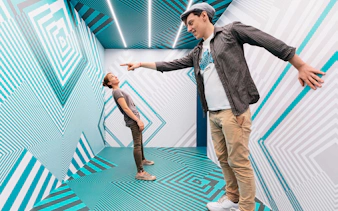 Visitors interacting in an optical illusion room at the Museum of Illusions.
