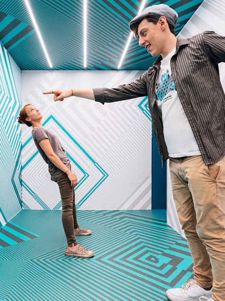 Visitors interacting in an optical illusion room at the Museum of Illusions.