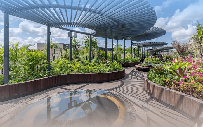 Pathway with greenery and modern pergola at Atlas Beach Club.